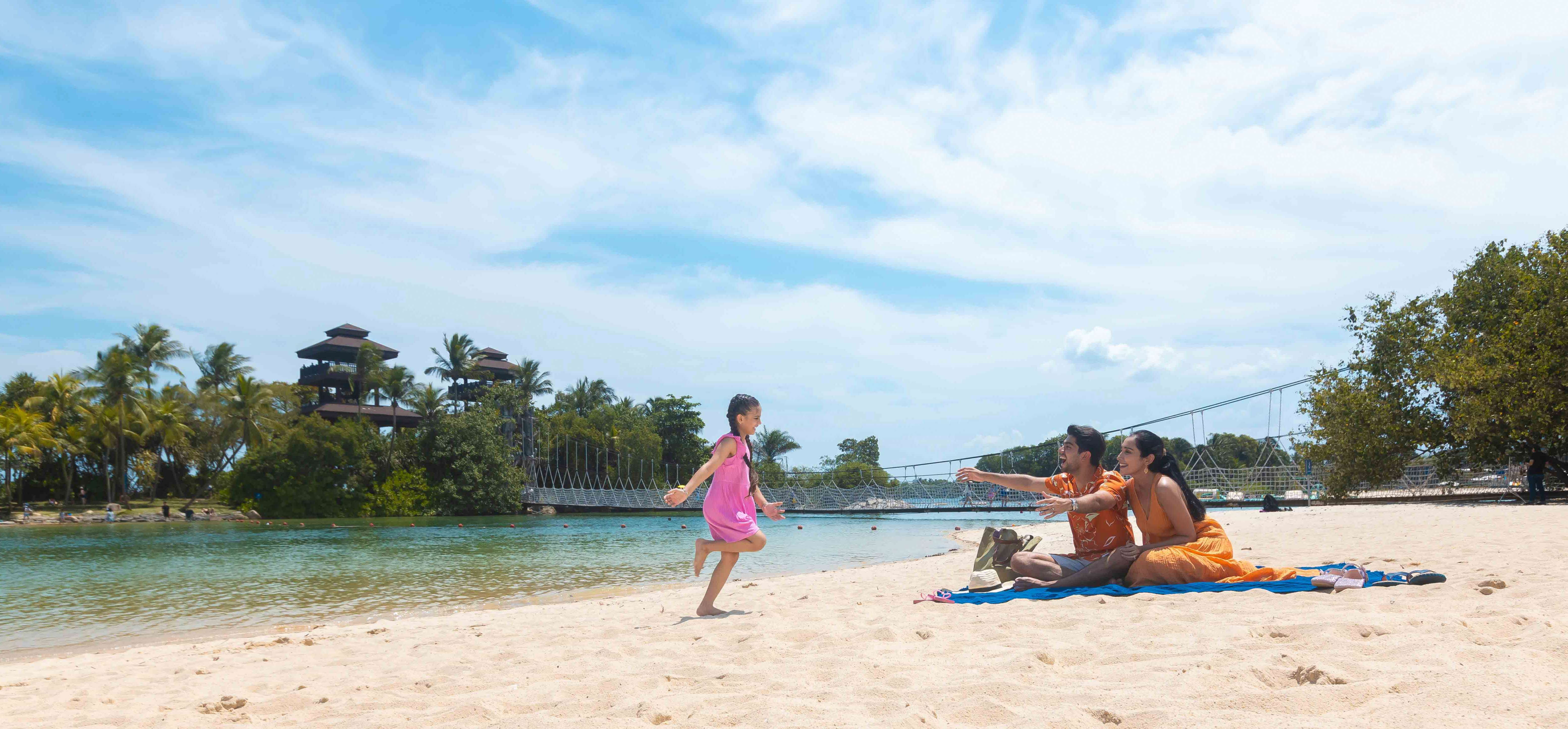A family enjoying bonding time by the beach on Sentosa